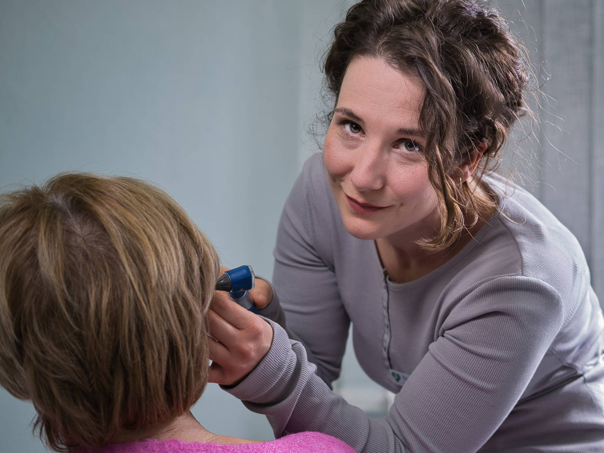 Foto einer Ärztin, die bei einer Patientin das rechte Ohr untersucht, Fotograf: Marco Sporleder