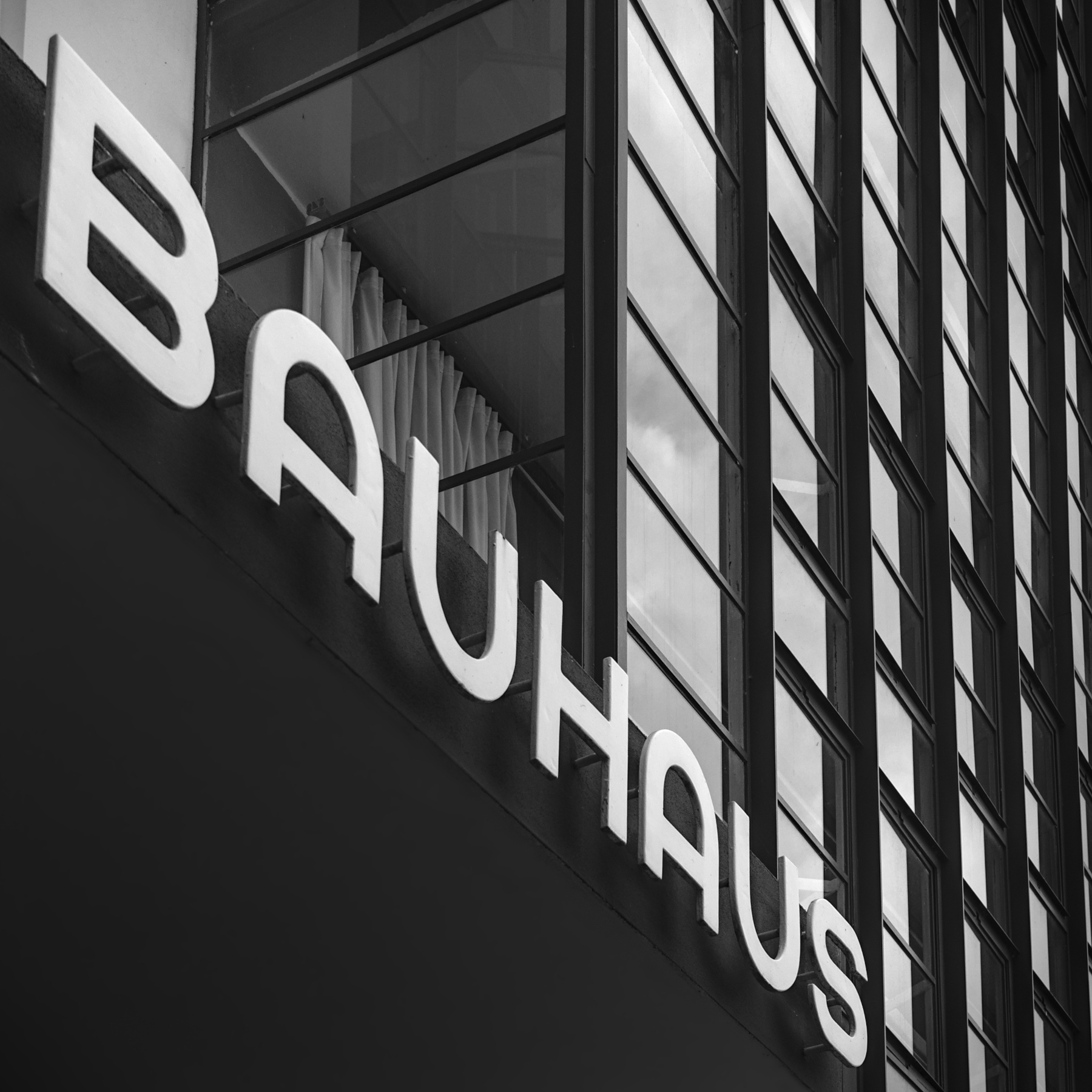 Foto vom Schriftzug Bauhaus über dem Haupteingang des Bauhaus in Dessau-Roßlau in schwarz-weiß, Fotograf: Marco Sporleder